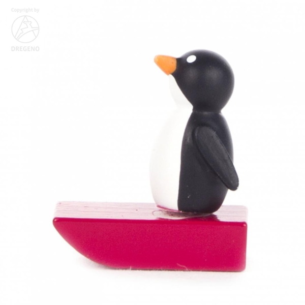 Pinguin auf rotem Schlitten